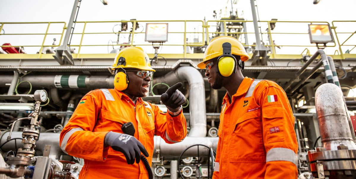 A group of Ghanaian engineers working together in a modern industrial setting.